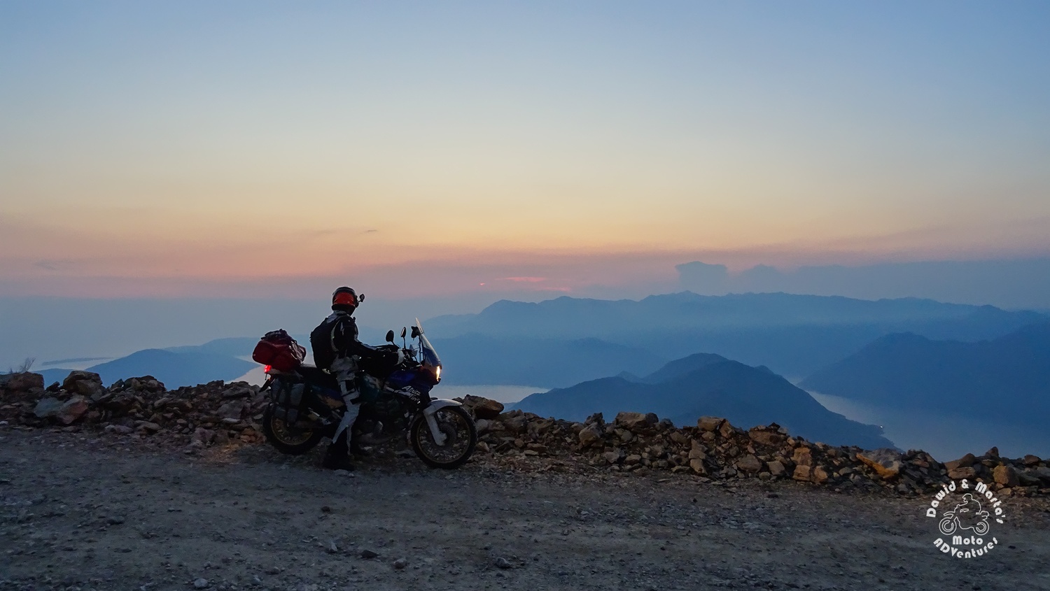 The Kotor Bay seen from the road to Lovcen National Park at the sunset and the Africa twin motorcycle